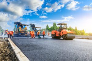a group of construction workers are working on a road.