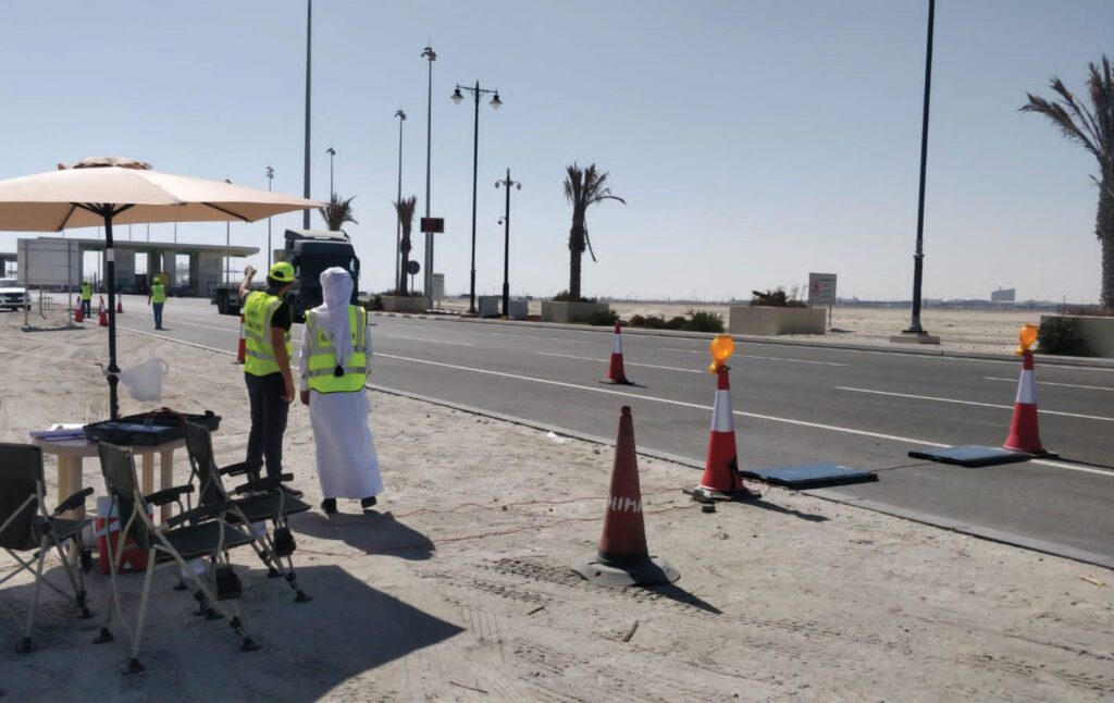 a group of people standing on a beach with umbrellas.