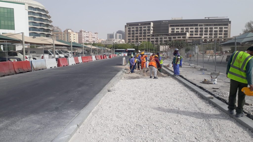 a group of construction workers are working on a road.