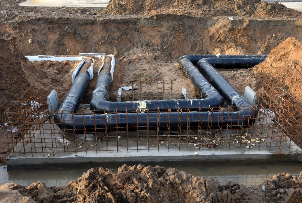 a construction site with pipes and pipes in the ground.