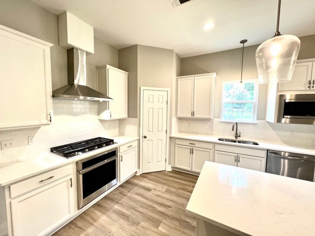 a kitchen with white cabinets and stainless steel appliances.