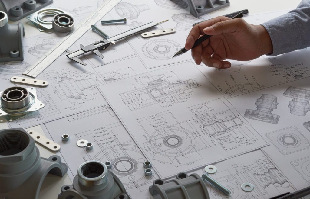 a man is working on a blueprint with a pen.