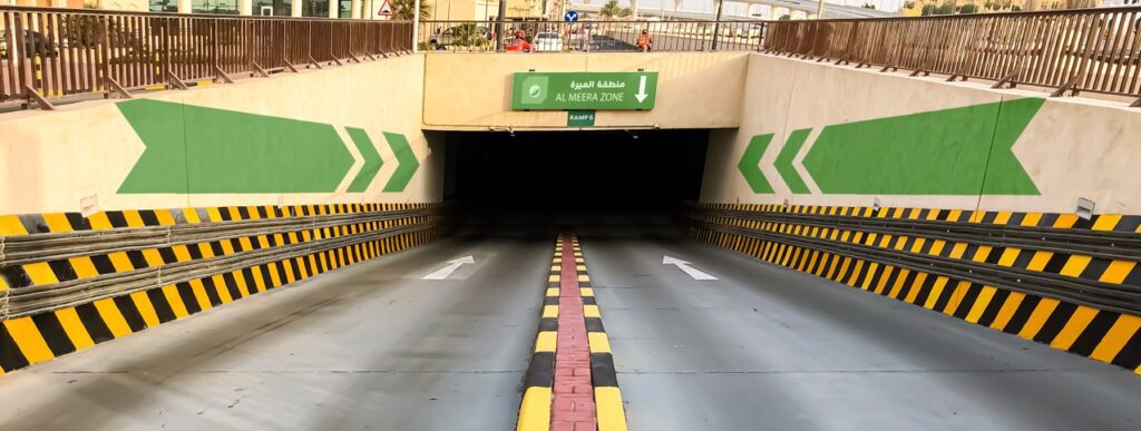 a tunnel with green arrows and a green sign.