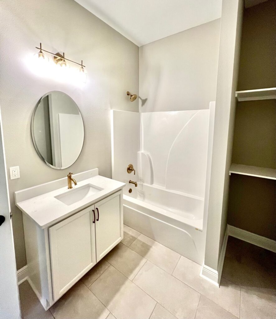 a white bathroom with a bathtub and sink.