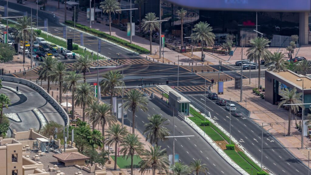 an aerial view of an intersection with cars and palm trees.