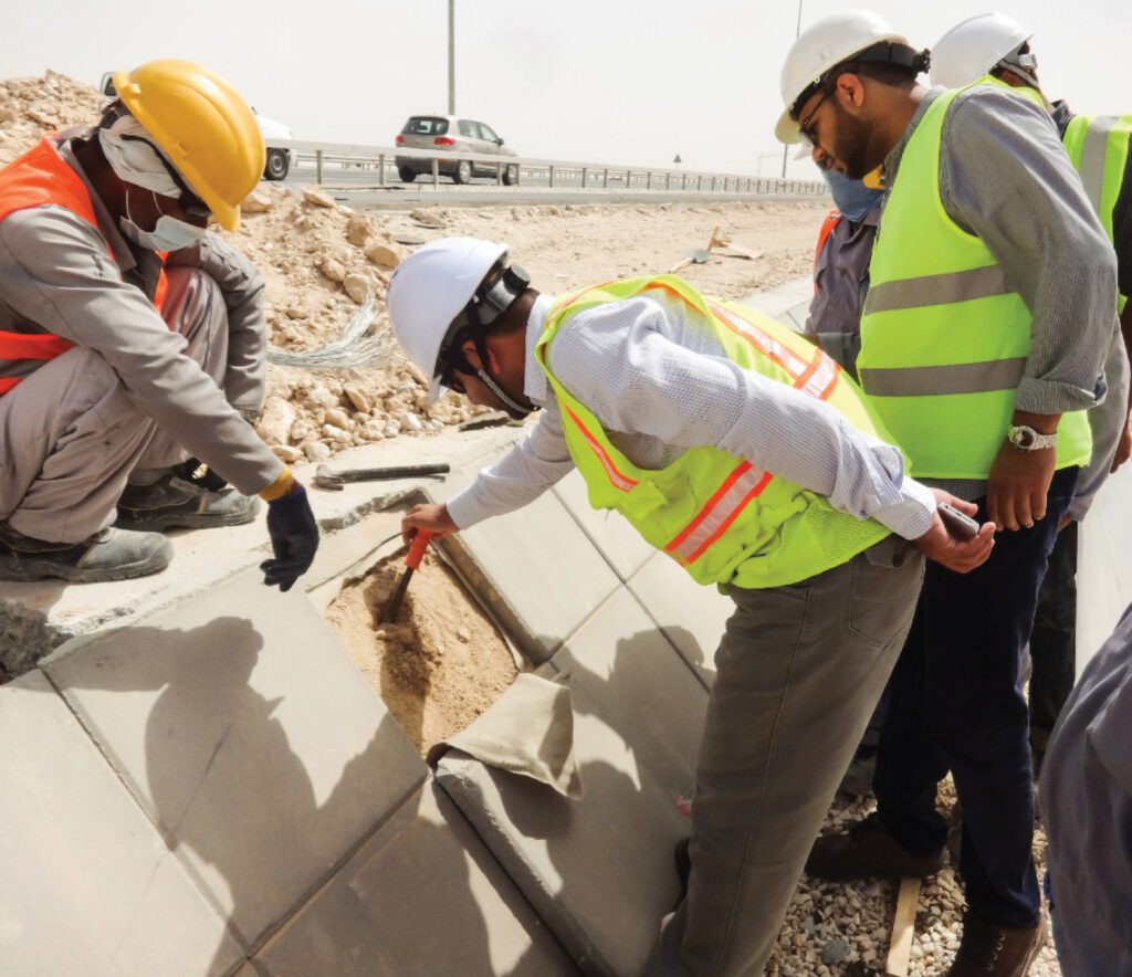 a group of construction workers are working on a road.
