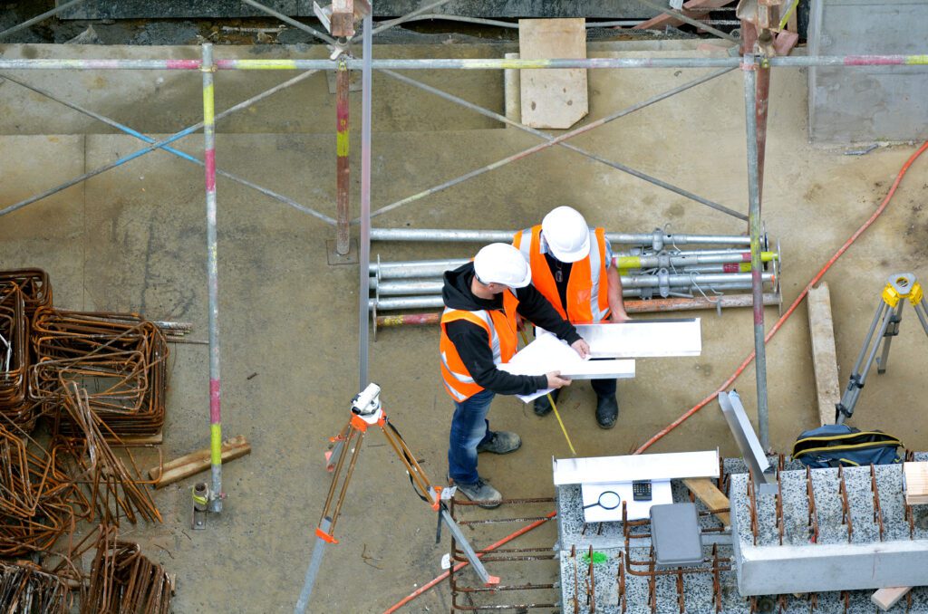 two construction workers working on a construction site.
